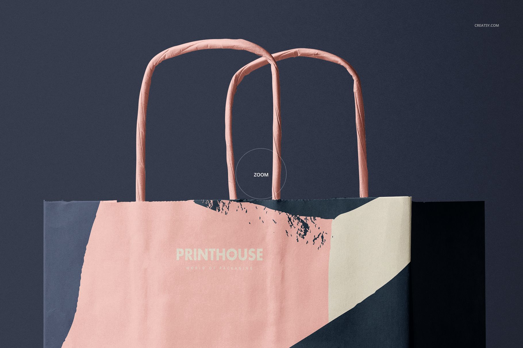 Close-up of a twisted handles paper bag mockup with geometric pink and cream design against a dark backdrop.
