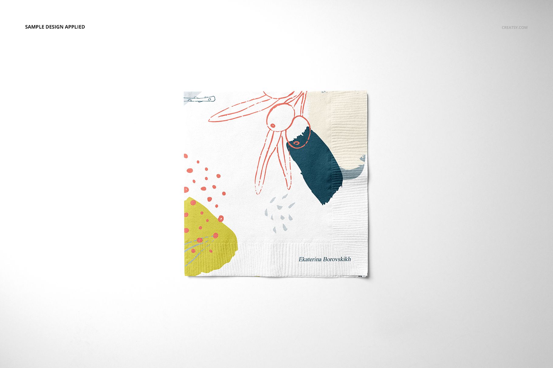 Square paper napkin with abstract colorful design, shown from top view on a light background in a mockup scene.
