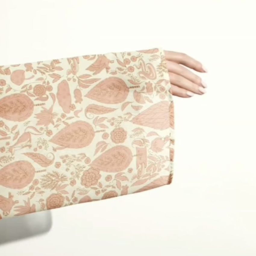 Chiffon kimono mockup showing a close-up of a sleeve with a peach and beige floral pattern, hand extended against a light background.