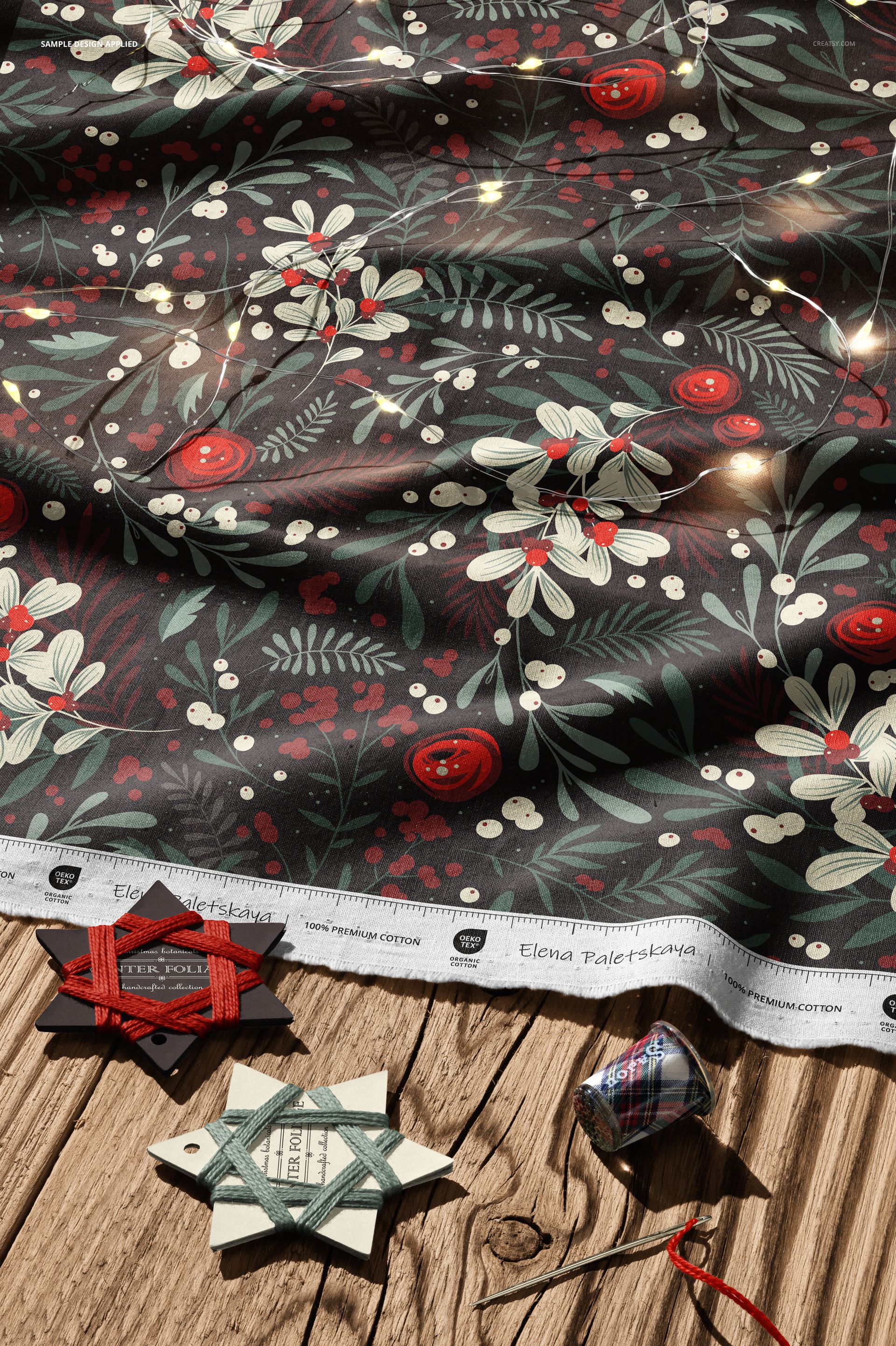 Christmas-themed cotton fabric mockup featuring red berries and white flowers, shown in a top-down perspective.