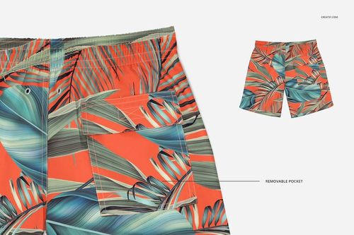 Swim trunks mockup featuring a vibrant orange base with green and teal palm leaf design, highlighting removable pocket.