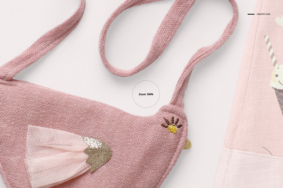 Close-up view of a pink textured baby blouse and shorts mockup set with bird-shaped pouch and embroidered details.
