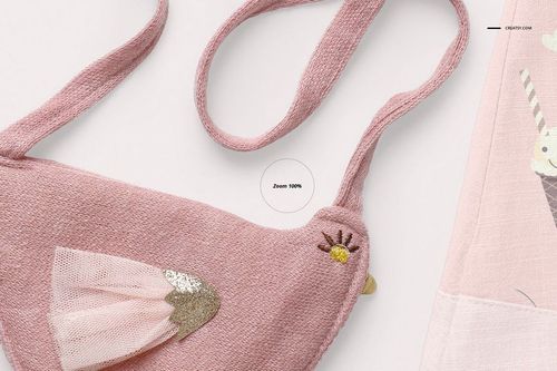 Close-up view of a pink textured baby blouse and shorts mockup set with bird-shaped pouch and embroidered details.