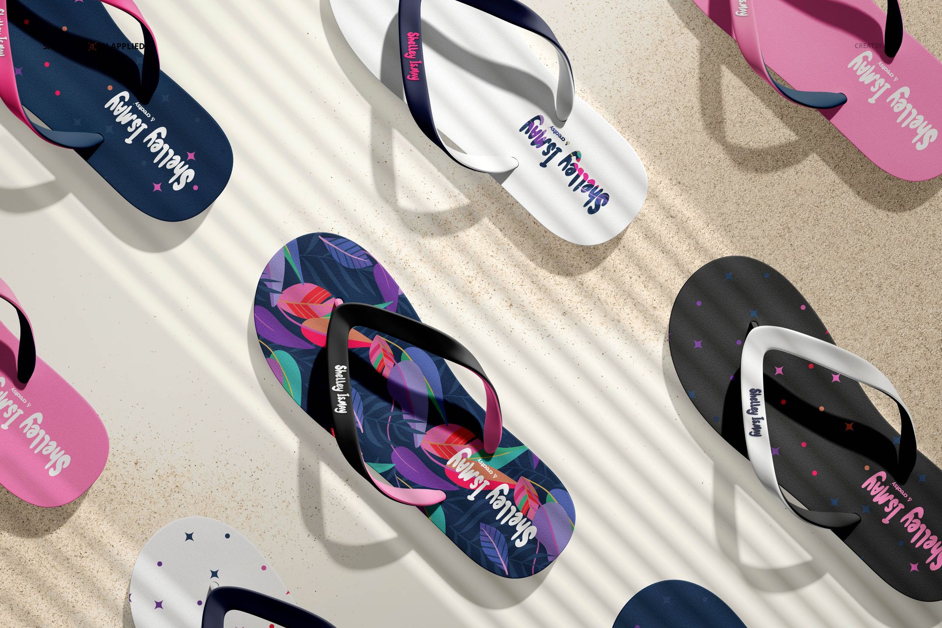 Flip flops mockup set showing different styles and colors placed on a textured sandy background, top perspective.