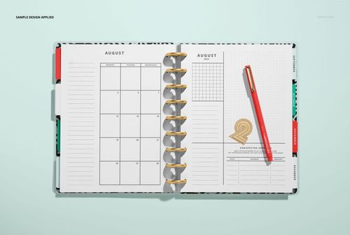Top view of a spiral planner mockup showing August calendar pages, gold binding, and a red pen on the right.