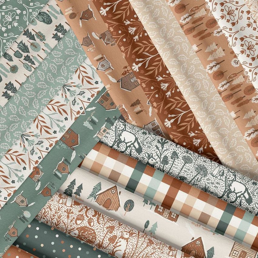 Folded fabrics mockup featuring multiple fabric pieces with woodland and geometric patterns in earthy green and brown tones.