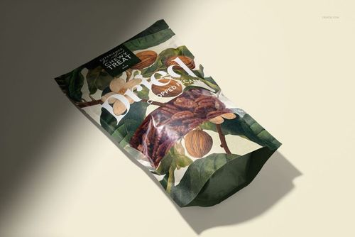 Paper pouch packaging mockup featuring chopped pecans, front view with leaf and nut illustrations, angled on a light surface.