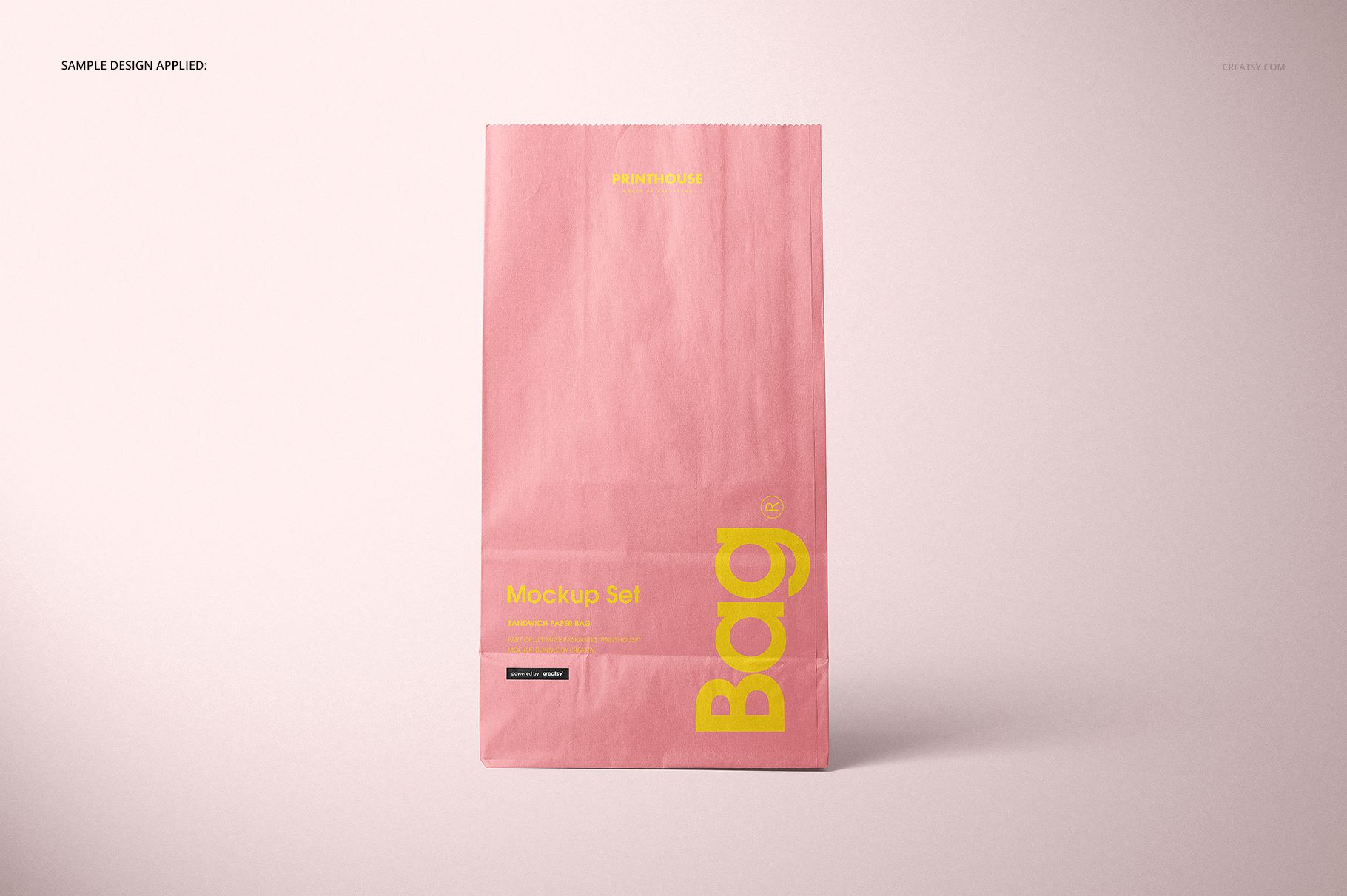Front view of a pink lunch bag with yellow text, standing upright against a light background in a packaging mockup.