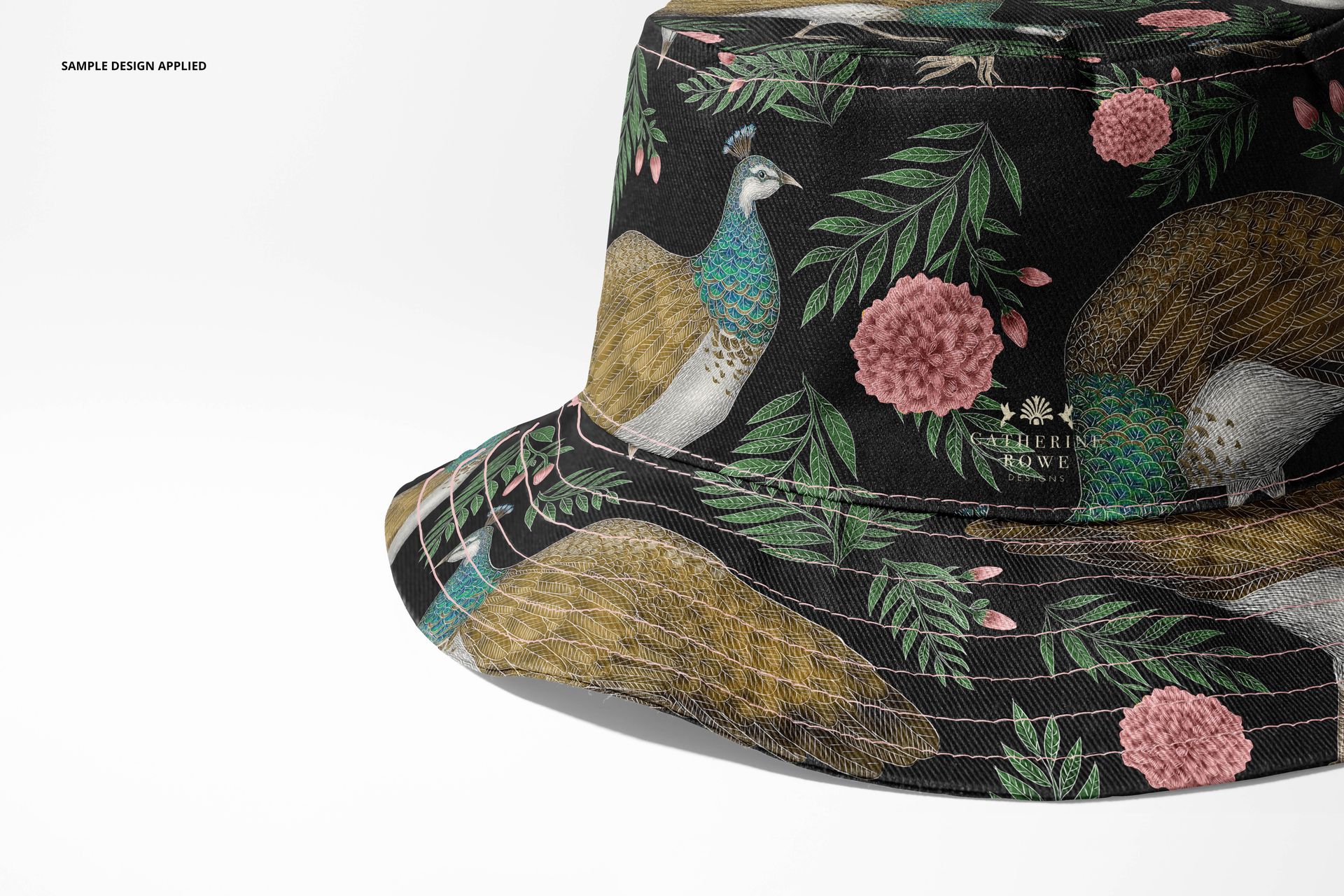 Front angled view of a reversible bucket hat mockup featuring a black background with peacock and floral pattern.
