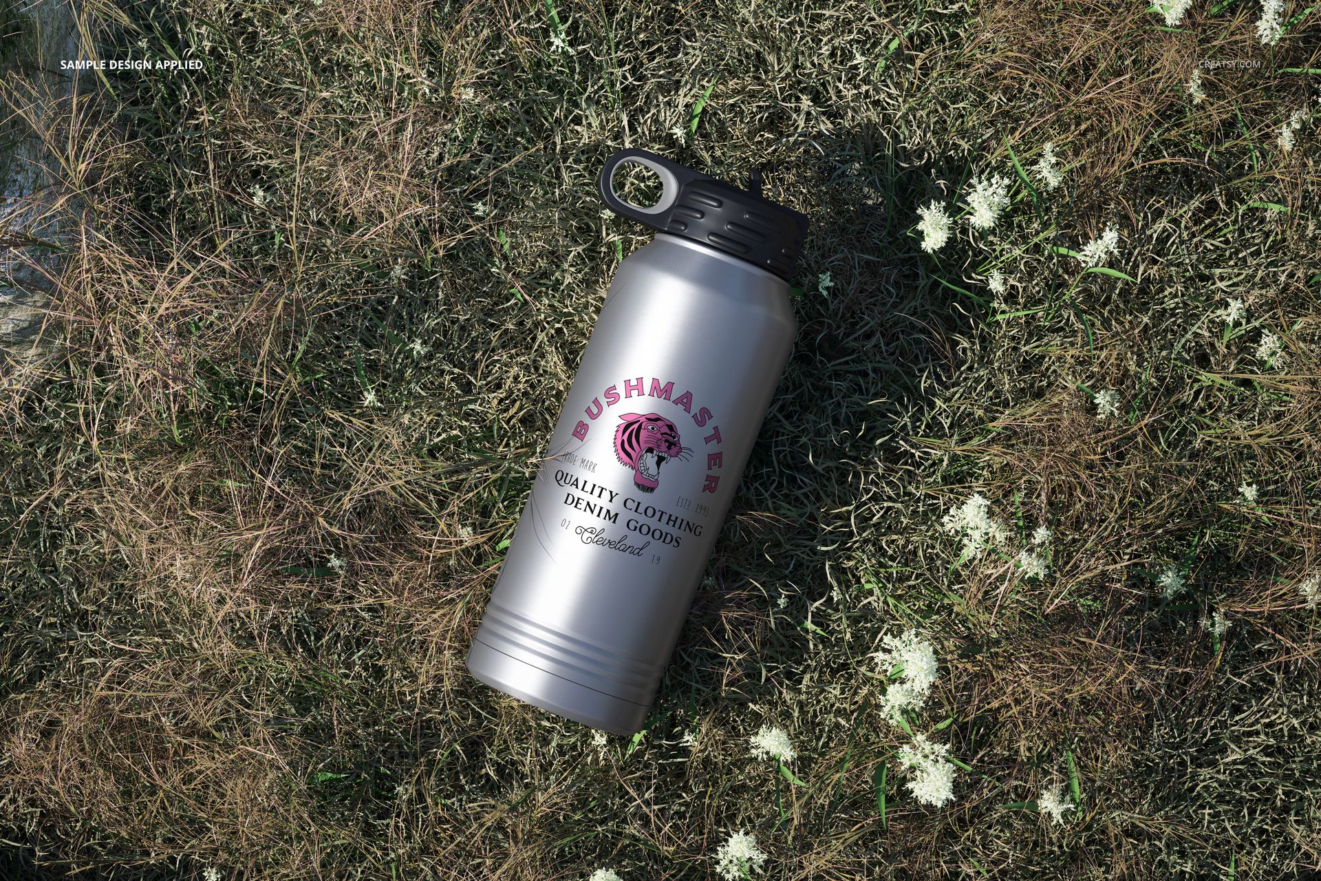 32 oz. stainless steel water bottle mockup featuring a printed design, placed on brown grass with white flowers.