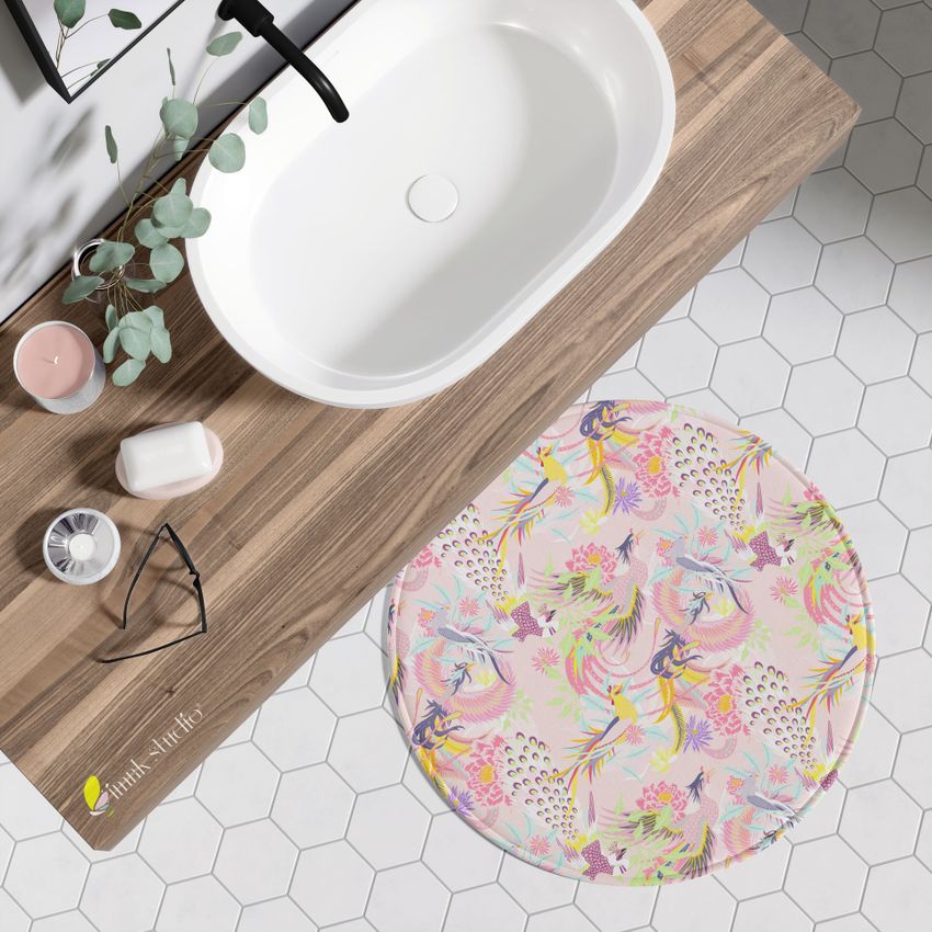 Round polyester bath mat mockup with a colorful floral and bird pattern placed on a white hexagon tile bathroom floor.