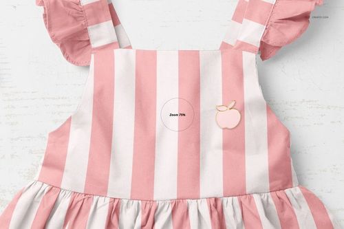 Front view of a baby dress mockup with wide pink and white vertical stripes, ruffled sleeves, and an apple patch detail.