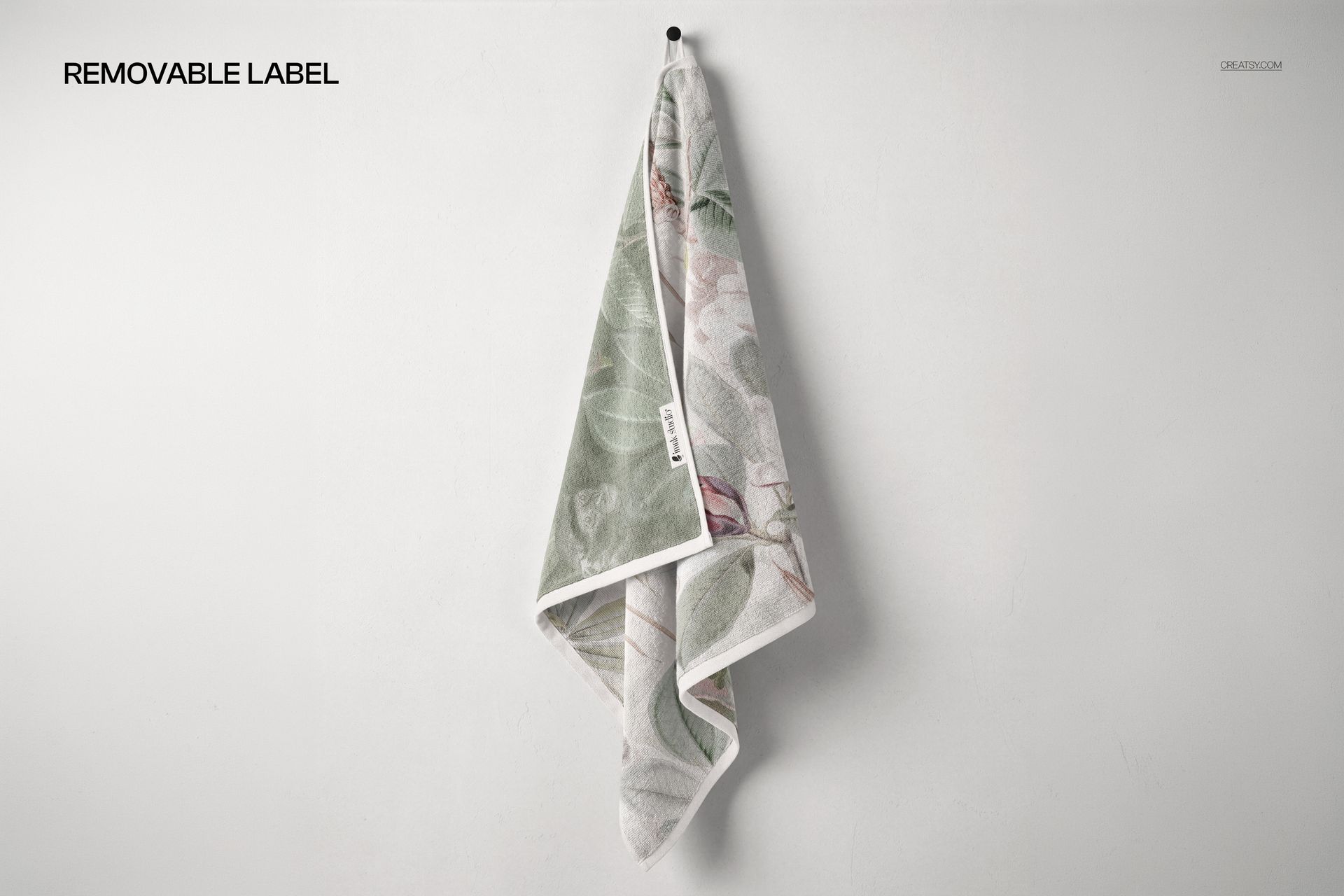 Towel mockup featuring a soft green and beige leaf design, shown from the front view with a removable label on the edge.