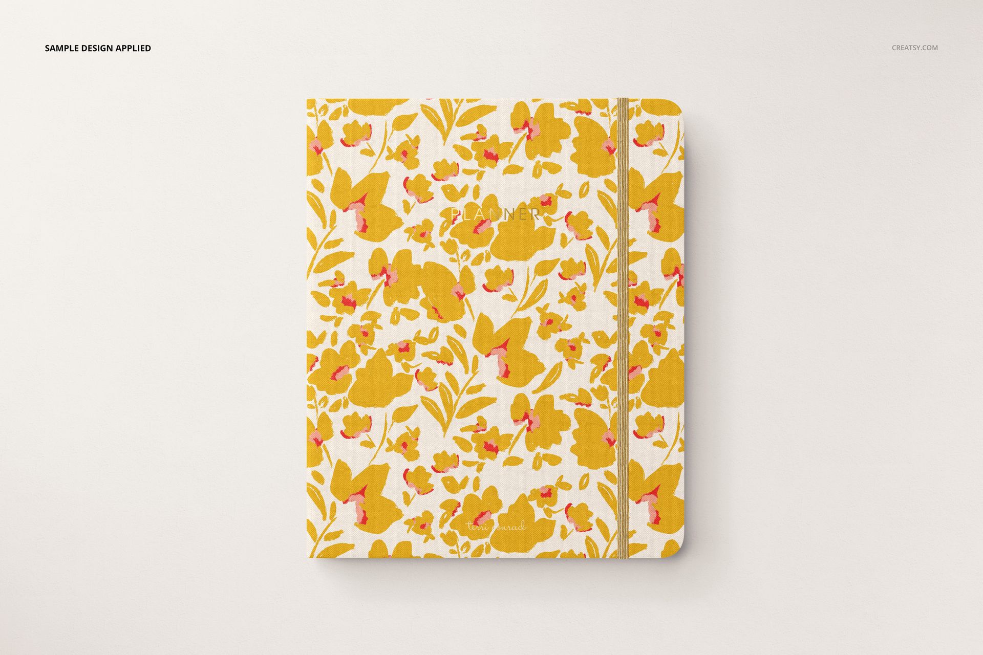 Stationery set mockup featuring a closed notebook with a white background and yellow floral design, top perspective.