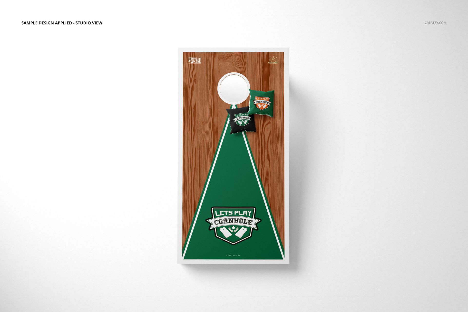 Cornhole board mockup with a wood grain surface, green triangle design, and two matching cornhole bags on top view.