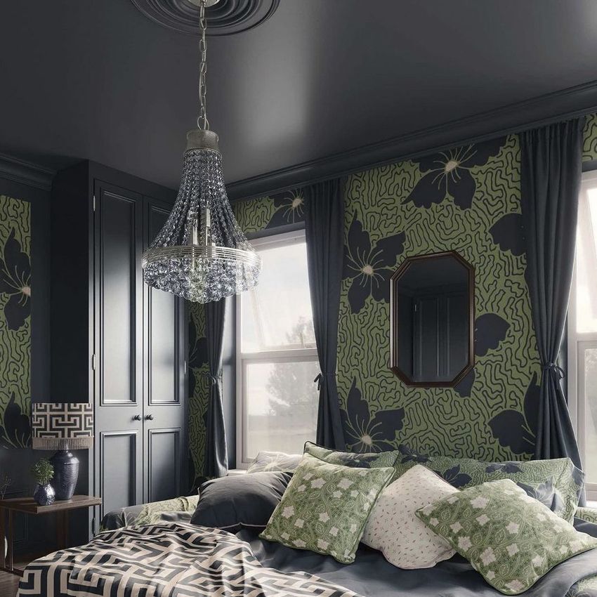 Bedroom mockup featuring patterned wallpaper with large floral designs, a crystal chandelier, and a bed with assorted pillows.