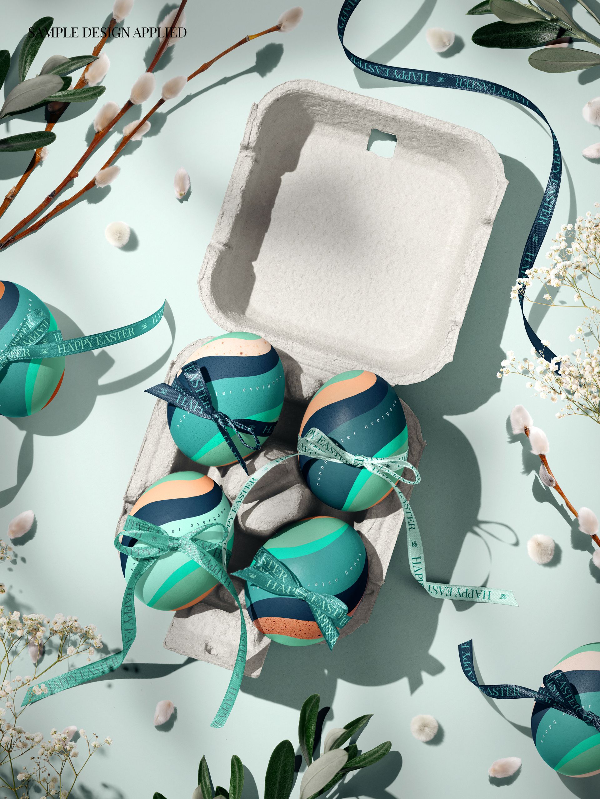 Easter egg PSD mockup featuring decorated eggs with ribbons in a carton box, viewed from above with spring plants.