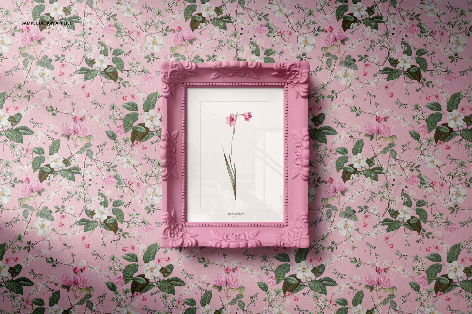 Ornate pink picture frame mockup showcasing botanical art, set against a pink wall with a floral pattern.