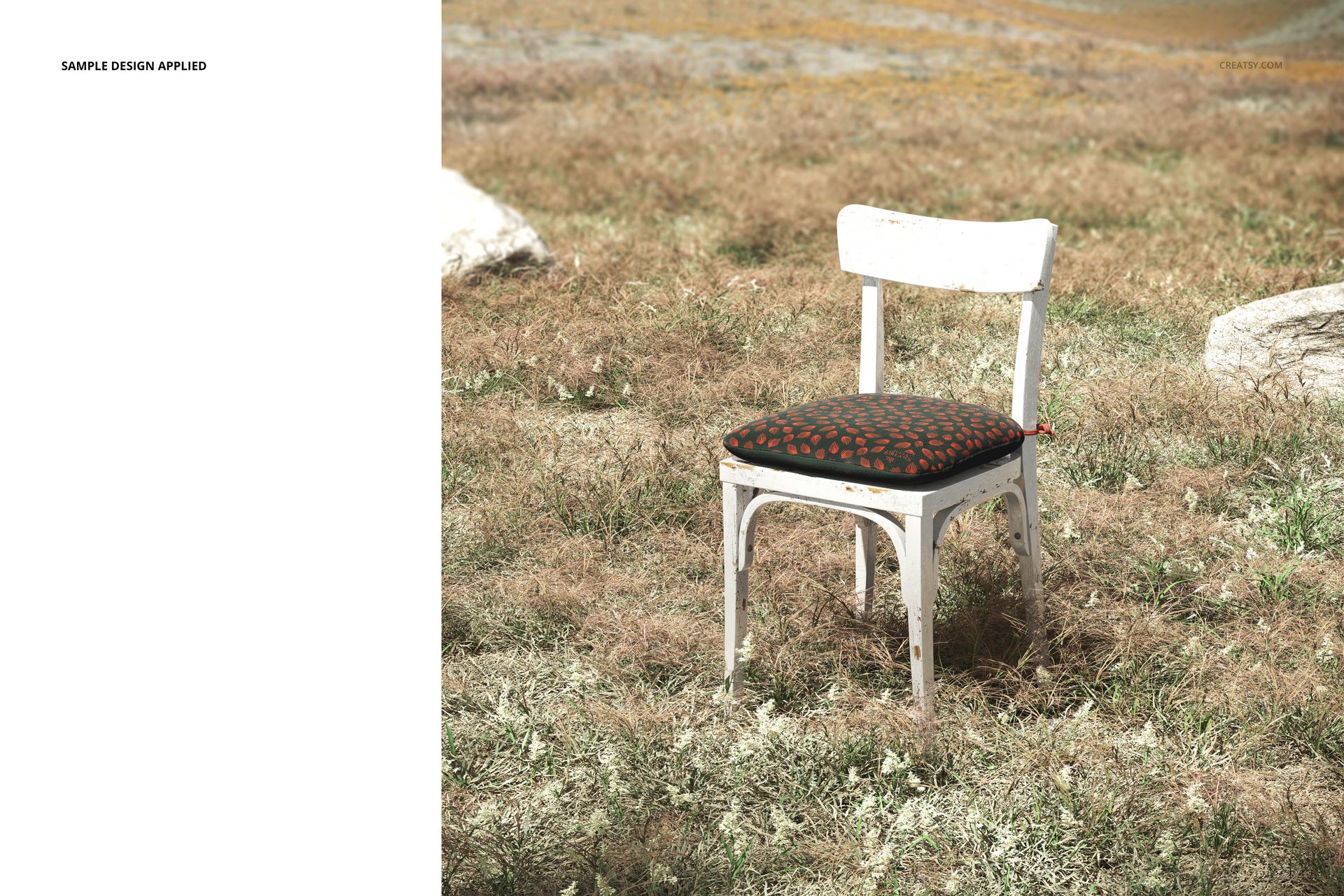 PSD mockup of a vintage chair with a decorative cushion, photographed outside on a sunlit, earthy landscape.