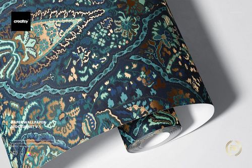 Close-up of a paper wallpaper mockup with intricate blue and gold floral design, displayed partially unrolled.