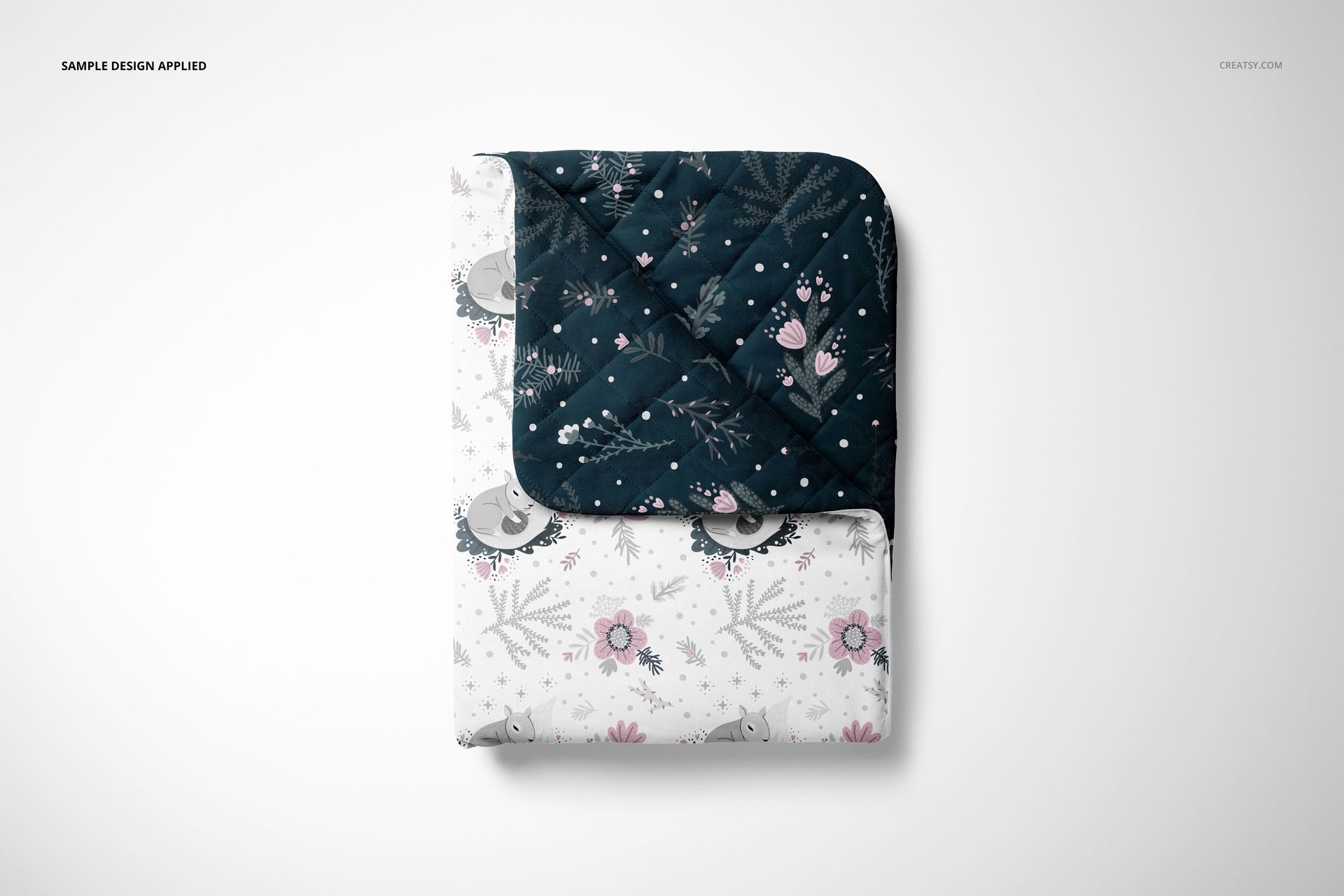Top view of a double-sided baby bedding set mockup with a pillow and quilt, showing contrasting patterns and colors.