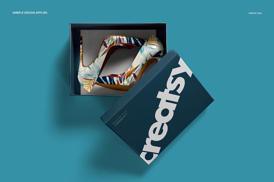Mockup of patterned high heels placed inside a partially opened box with bold text, viewed from above.