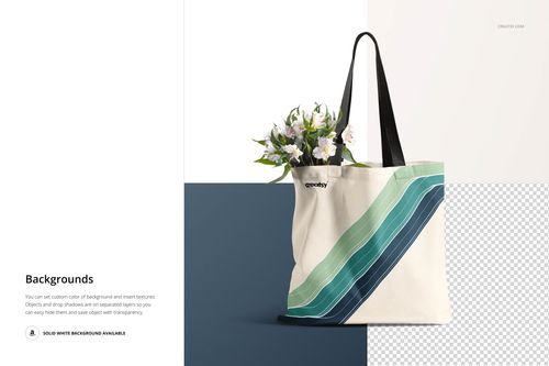 Front view of a canvas tote bag mockup with black handles, featuring green and blue diagonal stripes, filled with flowers.