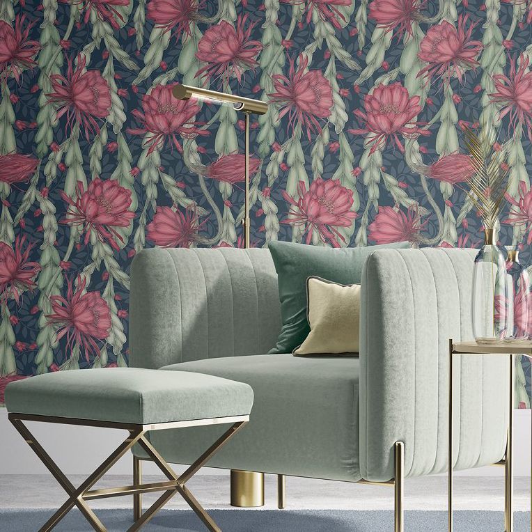 Velvet armchair and matching stool mockup in a modern room with a bold floral wallpaper, gold floor lamp, and soft pillow.