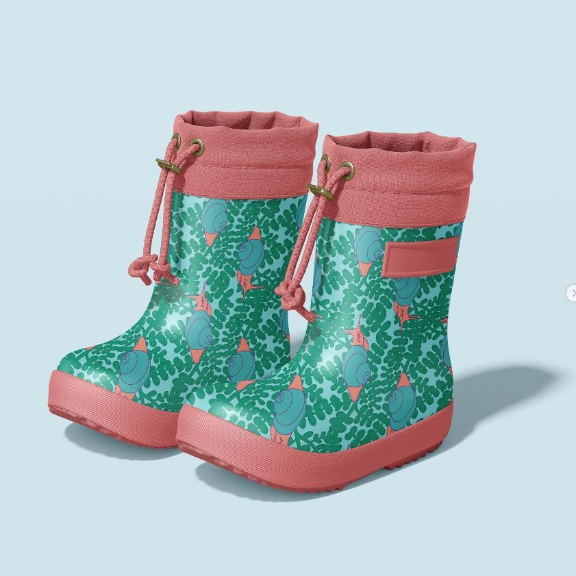 Rain boots mockup featuring a pair of kids' boots with a teal and green leafy pattern and pink trim, shown on a light blue background.