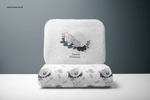 Mockup of a baby bedding set with pillow and quilt, decorated with soft gray and pink animal-themed patterns.