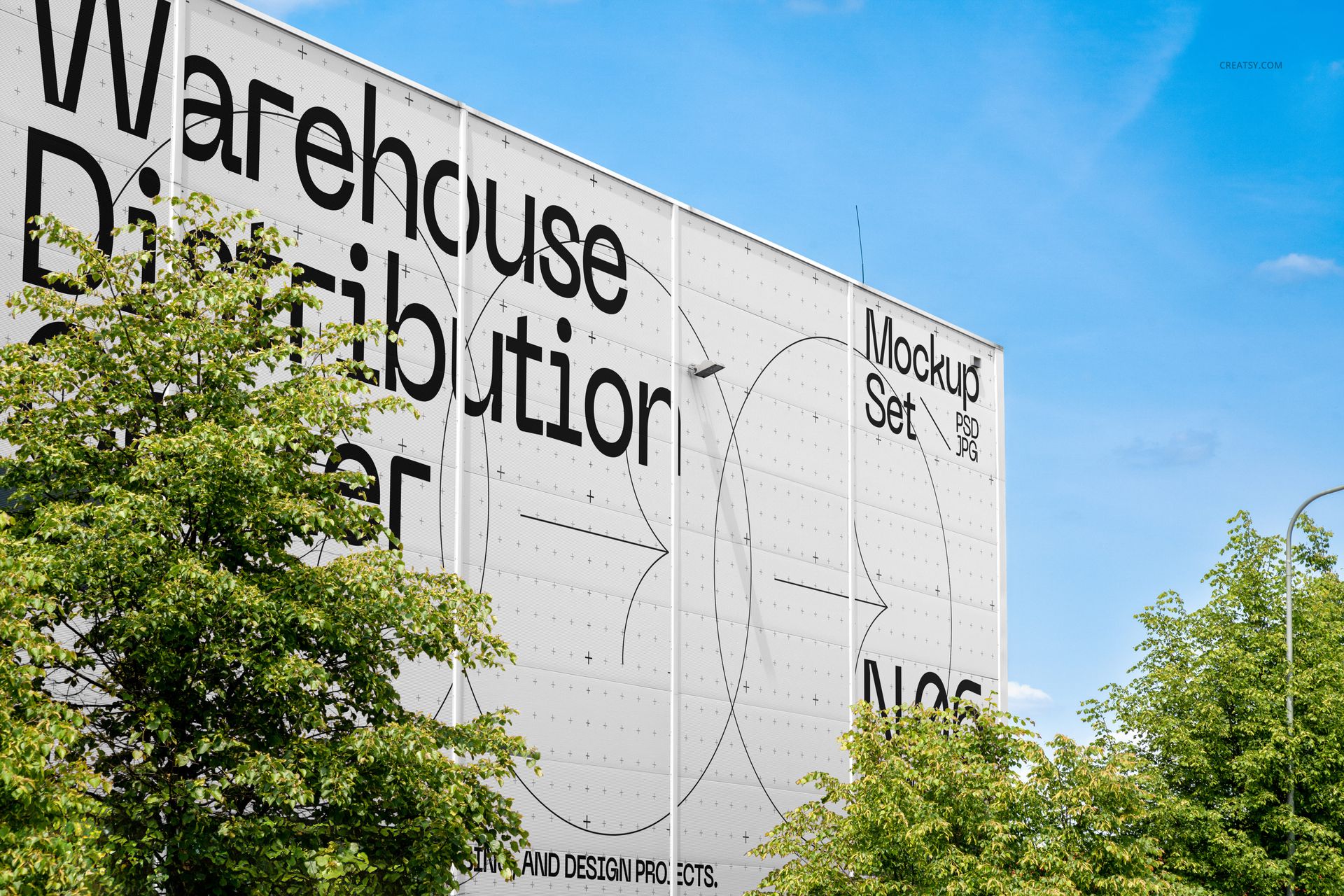 Front view of a distribution center mockup with white panel walls, black graphic lettering, and leafy green trees below.