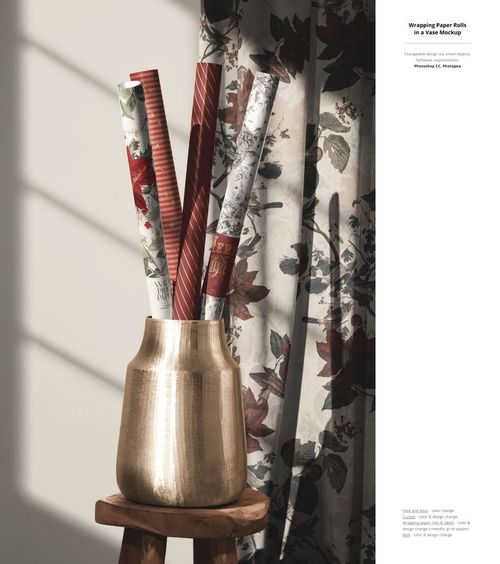 PSD mockup featuring assorted holiday gift wrap rolls in a shiny vase, set against a backdrop of botanical print curtains.