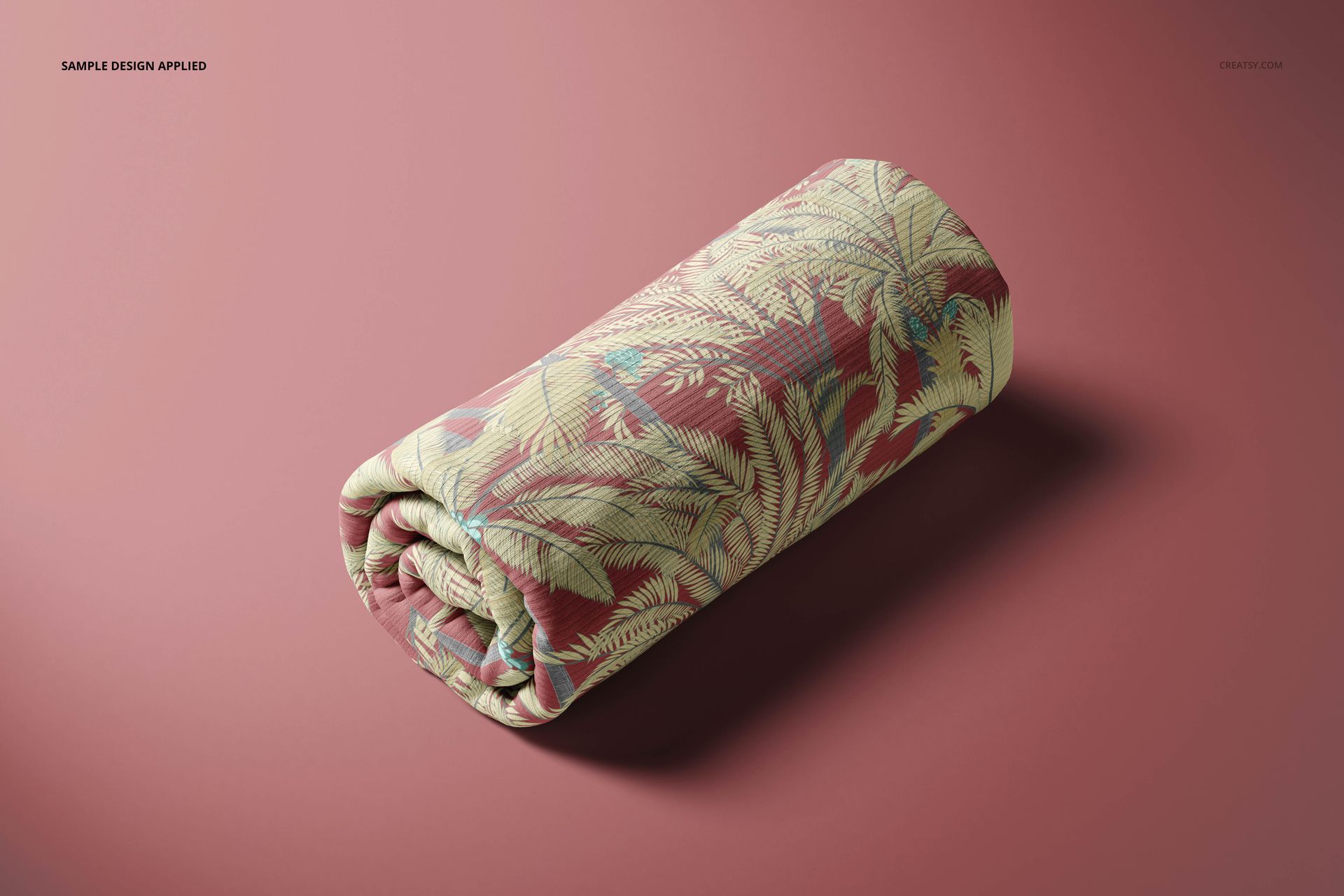 Rolled rib knit fabric mockup with a tropical leaf pattern in green and beige on a muted pink background, front view.