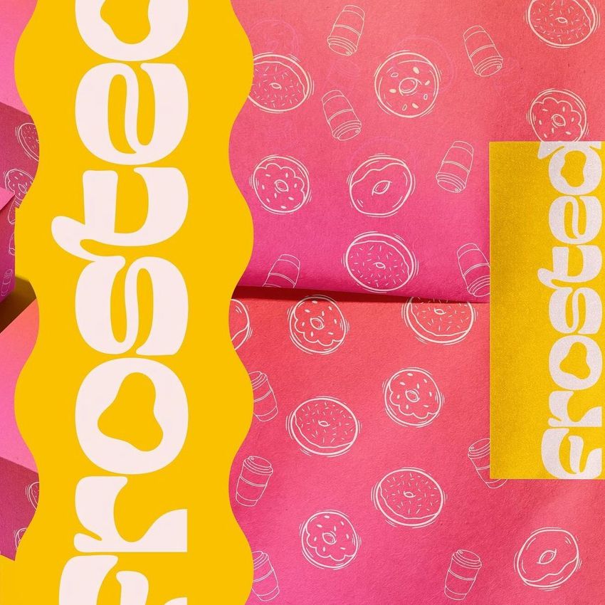 Wrapping paper mockup featuring a pink background with white donut and coffee cup illustrations, paired with a yellow sticker.