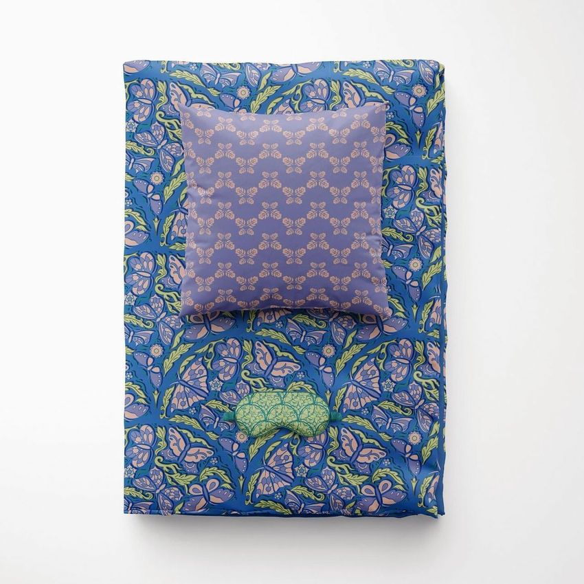 Folded duvet and pillow mockup featuring a blue and green floral pattern, viewed from above on a white background.