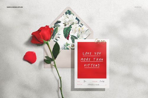 Top view of a Valentine's stationery mockup with a floral envelope, red rose, and greeting card on a light surface.