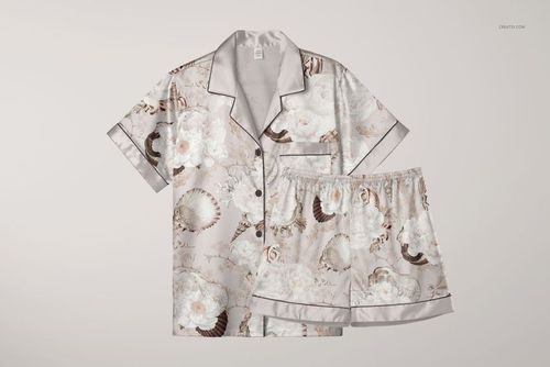 PSD mockup of adult silk pyjama shirt and shorts featuring white flowers and seashells, arranged side by side.