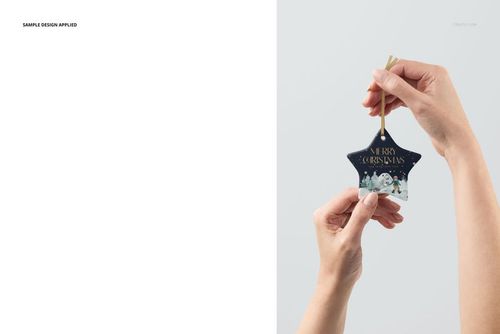Close-up of a star shape ceramic ornament mockup featuring a snowy landscape design, held by two hands.
