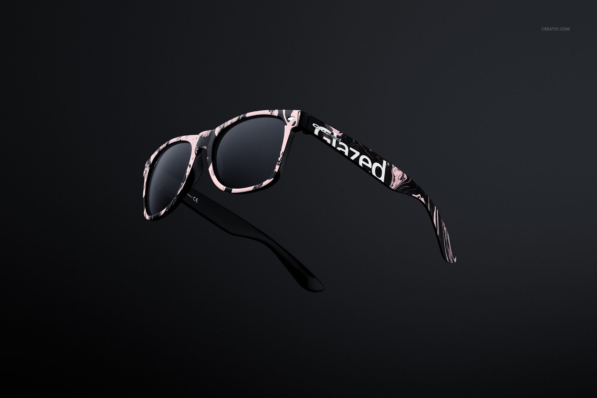 Front view of custom printed sunglasses mockup with a black frame and abstract pink and white pattern on a dark background.