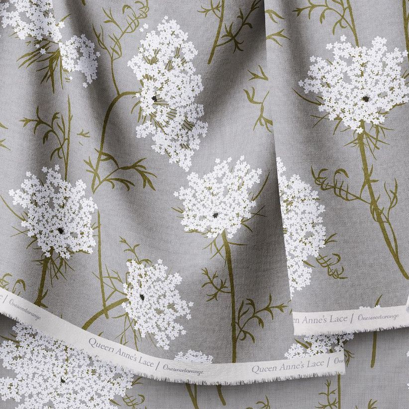 Hanging fabrics mockup featuring gray fabric with a white Queen Anne's lace floral pattern and text along the edge.