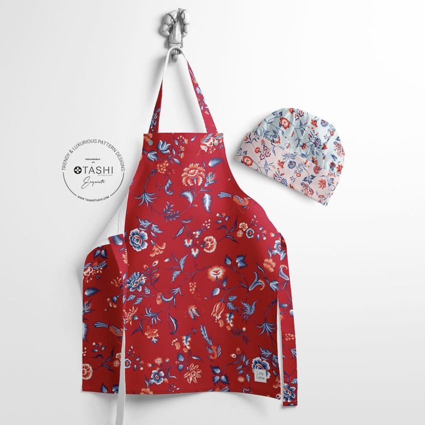 Kids apron mockup featuring a red apron with a colorful floral pattern, displayed on a white wall with a matching chef hat.