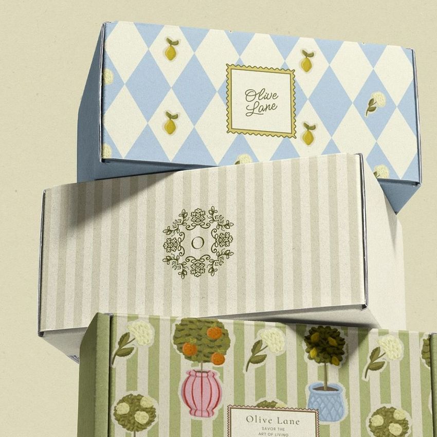 Mailing box mockup featuring three stacked boxes with pastel patterns, including stripes, diamonds, and floral designs on a neutral background.