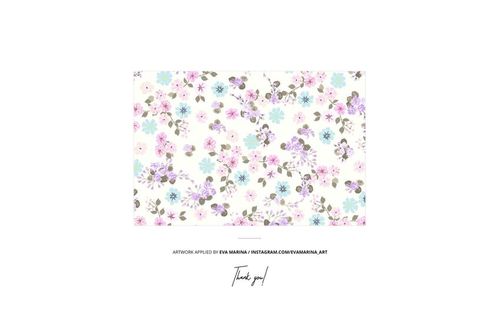 PSD mockup of jersey fabric stack with scattered flowers in soft pink, blue, and purple shades on a light surface.