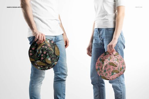 Reversible bucket hat mockup featuring two models holding hats with nature-inspired designs, standing side by side.
