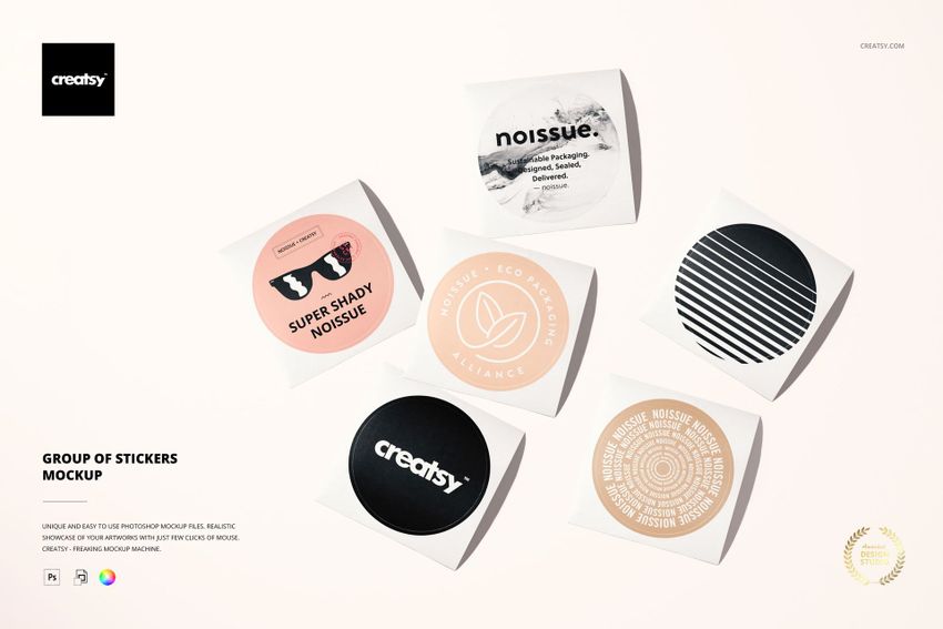 Top view of six round stickers in various colors and designs arranged on a light surface, packaging mockup scene.