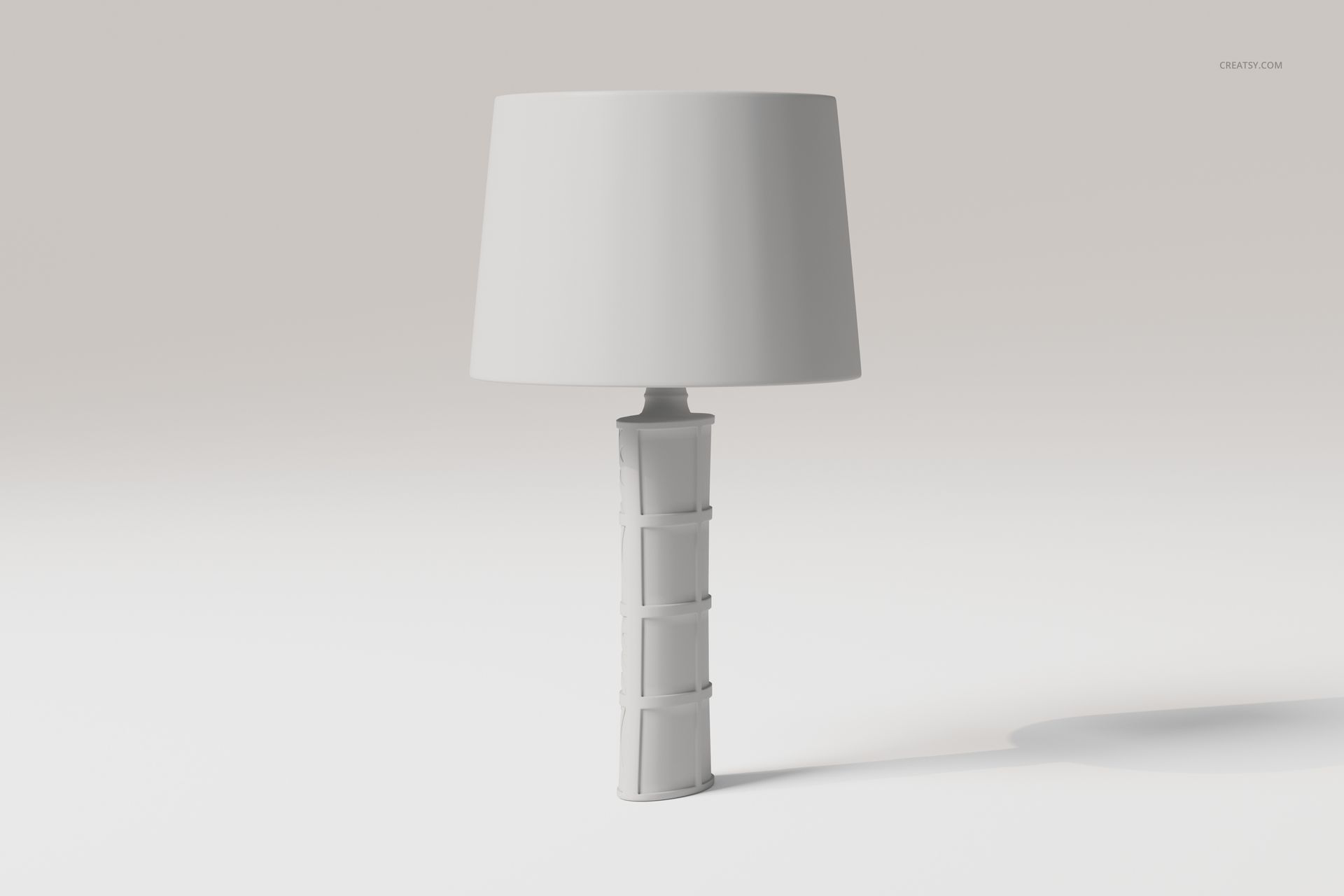 Front view of a decorative table lamp with a cylindrical base featuring geometric patterns and a plain white lampshade.