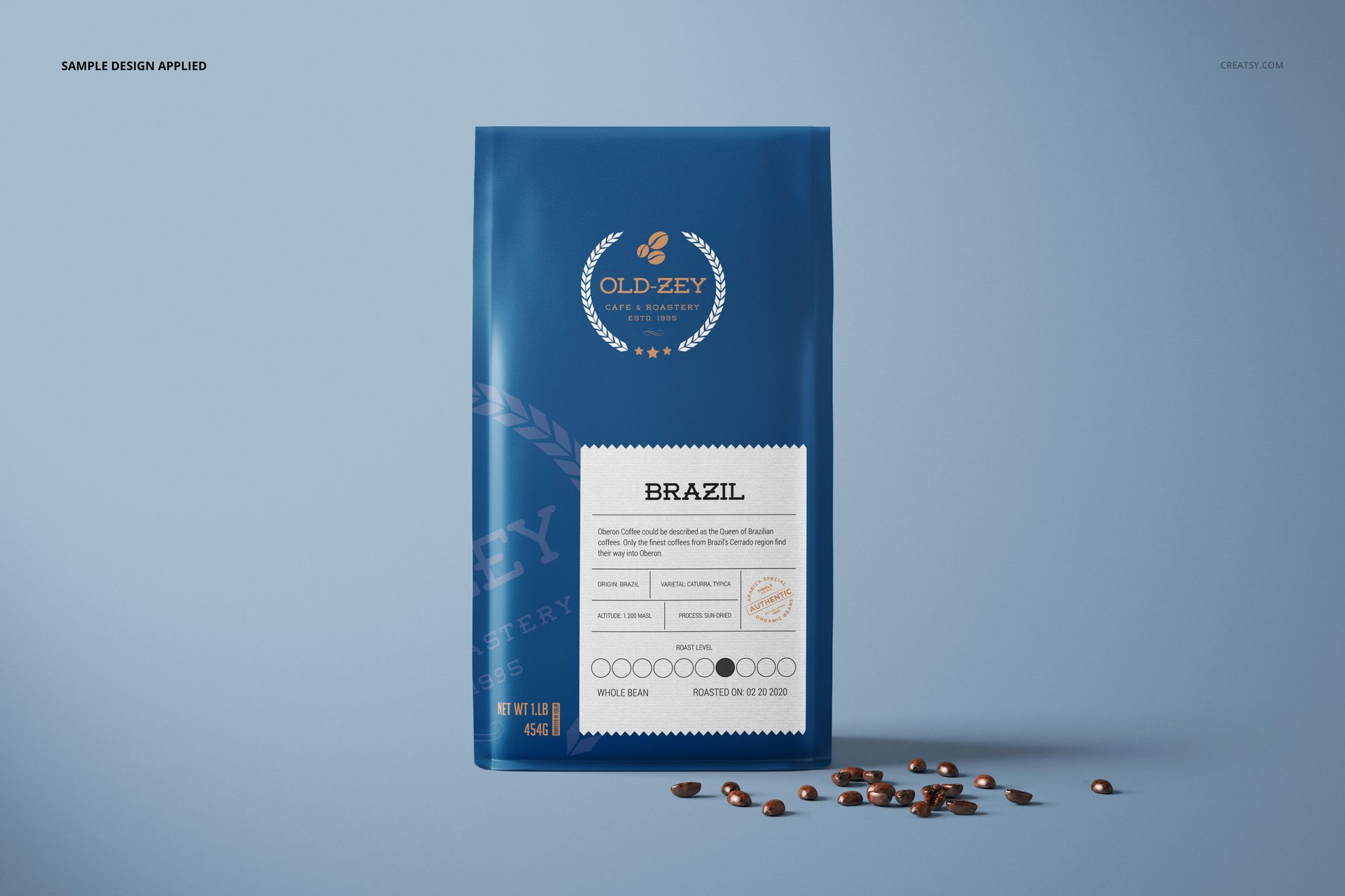 Blue paper coffee bag mockup shown from the front, featuring a sample design and scattered coffee beans on the right.