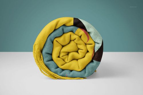 Tassel fringe blanket mockup in PSD format, rolled up to reveal textured fabric and multicolor design elements.