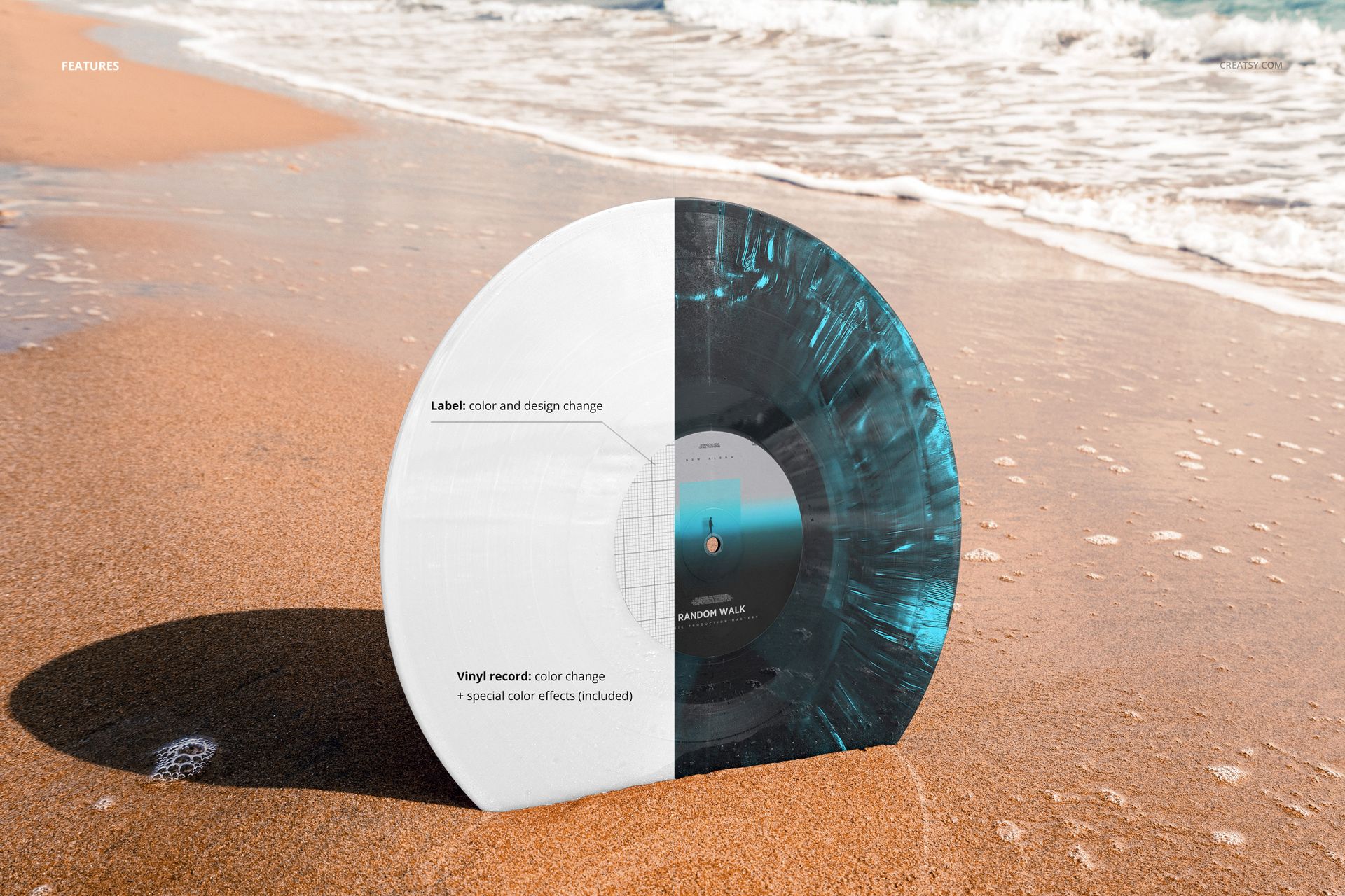 Vinyl record mockup with half white and half blue marbled design standing upright on sandy beach near the water.