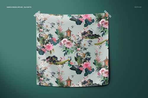 Square furoshiki fabric wrap mockup with floral and nature pattern, front view against a dark green background wall.